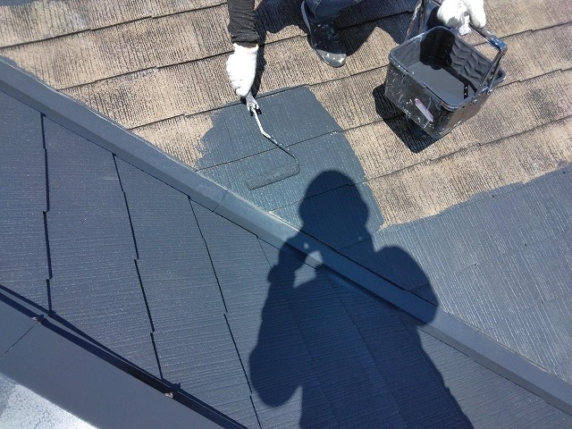 大月市の修繕・塗装工事における屋根の上塗り塗料重ね塗りの様子